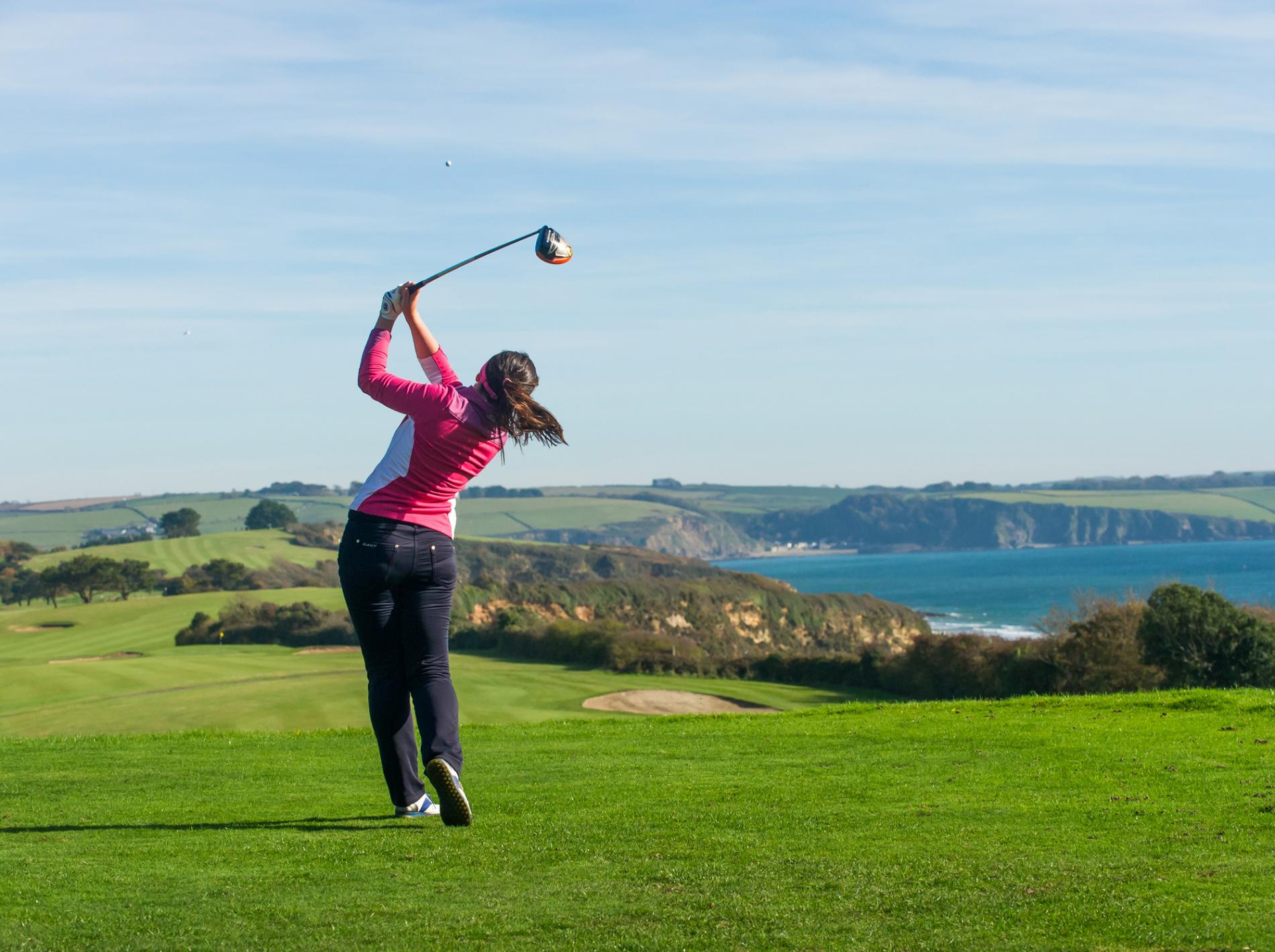 lady golfer taking shot on 1st tee carlyon bay