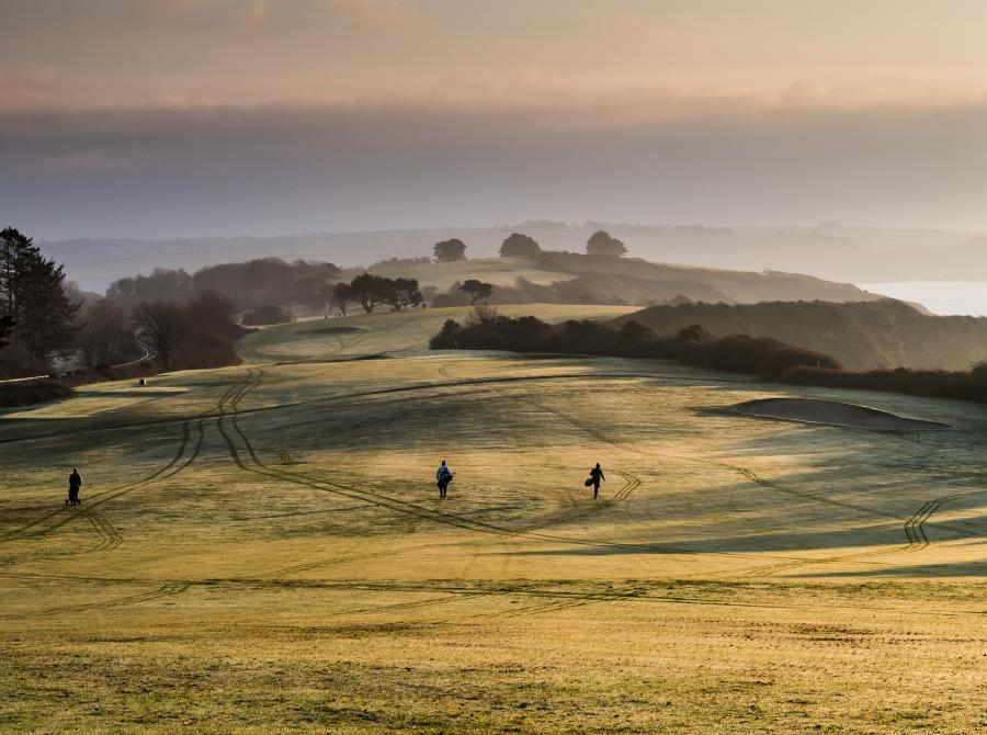 golfers on carlyon golf course early morning dew
